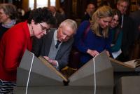 Symposium guests examining the Lectionaries side by side